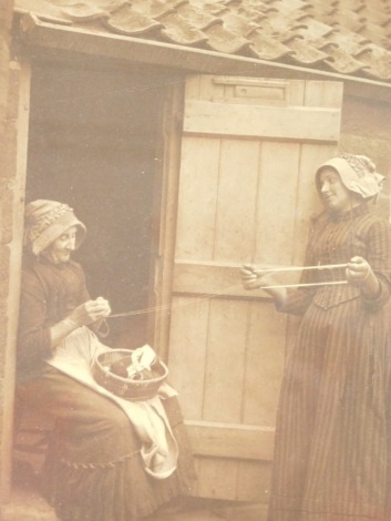 Francis (Frank) Meadow Sutcliffe (1853-1941). Two women winding wool, gelatin carbon print, signed in pencil, 29cm x 20cm.