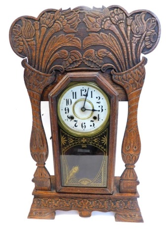 A late 19thC American mantel clock, in carved walnut gingerbread style case, stamp to dial Made By The New Haven Clock Company New Haven Connecticut, with gilt embellishment, on bracket feet, 63cm high.