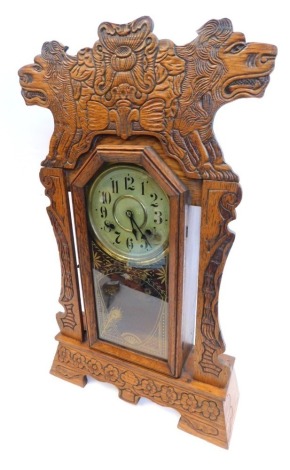 A 19thC gingerbread clock, with 13cm diameter, Arabic dial, marked Newhaven Clock Co, USA in heavily carved cased, with pendulum, 64cm high.