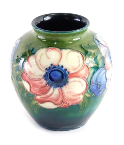 A Moorcroft pottery floral pattern vase, on green ground, impressed marks beneath, 10cm high.