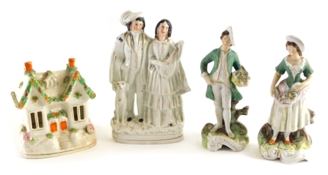 A pair of 19thC semi porcelain figures of a lady and a gentleman, each holding baskets, a Staffordshire pastille burner, 15cm high and a further Staffordshire flatback figure of a lady and gentleman aside dog. (4)