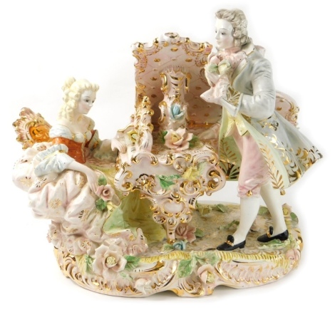 A highly decorative Capodimonte lamp base, of a lady playing grand piano aside gentleman, each dressed in finery with gilt highlights, on a floral base, profusely polychrome decorated, predominantly in pink and yellow, marked beneath, 39cm high.