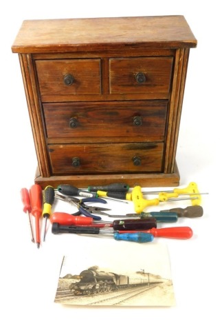 A 19thC table top pine chest miniature, of two short and two long drawers, with some contents, including a early 20thC photograph of locomotive 60046. 17cm x 21cm