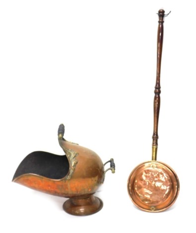 An early 20thC copper and brass coal helmet, with two fixed handles on inverted stem and circular foot, 47cm high and a copper warming pan with turned handle.