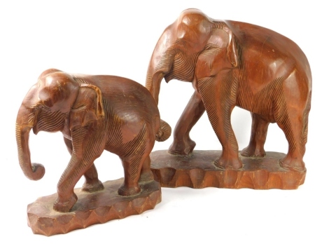 A graduated pair of carved wooden tribal elephant figures, 39cm high, etc. (2)