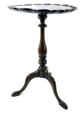 An early 20thC walnut wine table, the solid top with a leaf carved border, on a turned column and tripod base, 59cm high, 38cm wide.