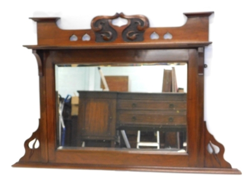 A late 19thC walnut overmantel mirror in Art Nouveau style, with a carved and pierced crest, and a shelf above a bevelled glass plate, 77cm high, 119cm wide.