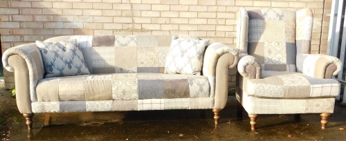 A two seater sofa in 19thC style, upholstered in various pieces of patterned tweed, 196cm wide, and a matching wingback chair,