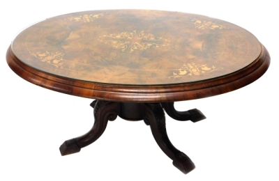 A walnut and marquetry coffee table, the oval top with a moulded edge on four turned columns and carved splayed legs, formed from a Victorian loo table, 100cm wide.