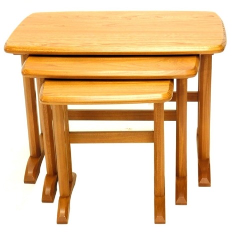 A nest of three Ercol elm tables, each with faceted legs, the largest 61cm wide.