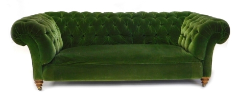 A Victorian mahogany Chesterfield sofa, upholstered in green buttoned fabric on turned legs with brass castors, 202cm wide.