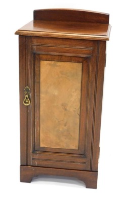 An Edwardian walnut and figured walnut pot cupboard, with a raised back and a panelled door, on bracket feet, 77cm high, 38cm wide.