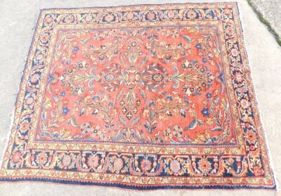 A Persian rug, with a central pole medallion, with scrolls and flowers, leaves, etc., on a red ground with one wide and two narrow borders. 200cm x 164cm.