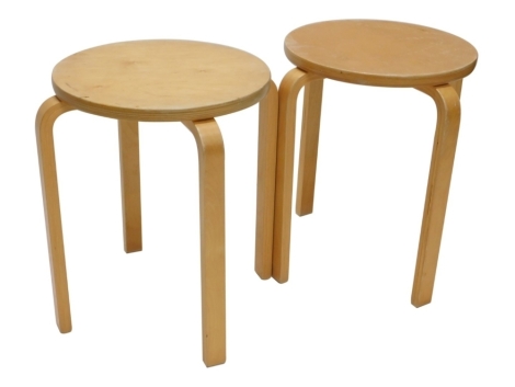 A pair of birch laminate Modernist style tables, each with a circular top and four bentwood legs, 46cm high, the top 35cm diameter.