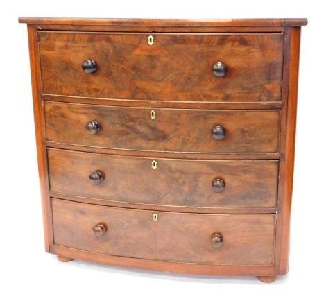 A Victorian mahogany bow fronted chest of drawers, the top drawer with a cross banded border, above a further three drawers, each with turned wood handles, on later bun feet, 107cm high, 110cm wide.