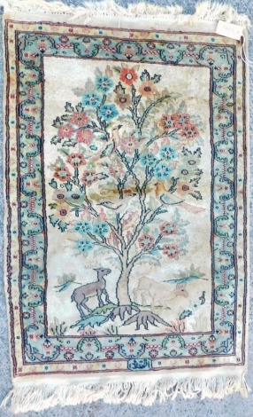 An Eastern silk type mercerised cotton rug, decorated with Tree of Life, deer, etc., within two narrow borders, 95cm x 66cm.