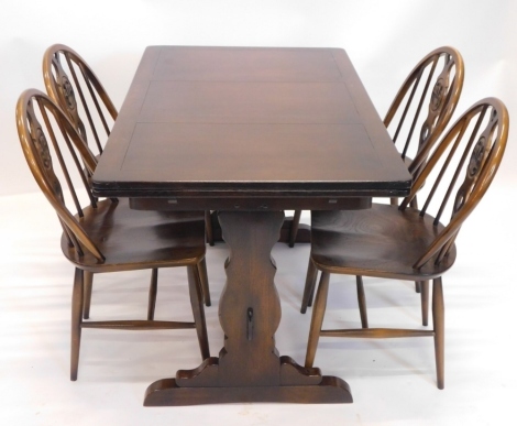 An Ercol dark oak draw leaf dining table, the rectangular top on shaped end supports, 74cm high, 114cm wide when closed, and four matching chairs.