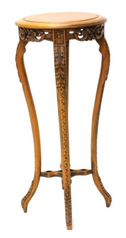 A beech plant stand, with a circular top, pierced and carved frieze on leaf carved cabriole legs with stretcher, 89cm high, 40cm deep.