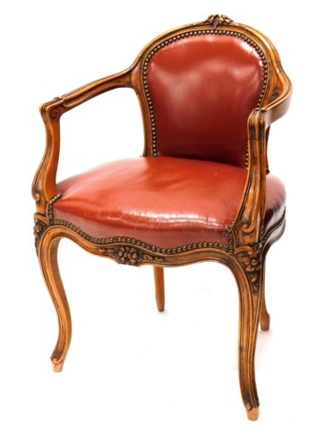 A French beech open armchair, with a red leather padded back and seat on cabriole legs. The upholstery in this lot does not comply with the 1988 (Fire & Fire Furnishing) Regulations, unless sold to a known exporter or upholsterer it will be cut from the f