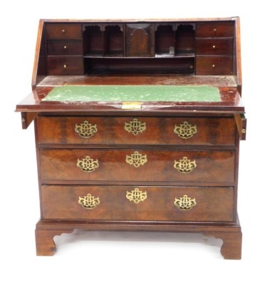 A George II figured mahogany bureau, the fall enclosing a fitted interior above four graduated drawers, with brass drop handles on bracket feet, 95cm wide.