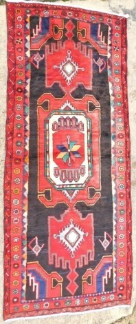 A Persian Hamadan runner, with multicoloured geometric design, 285cm x 117cm.