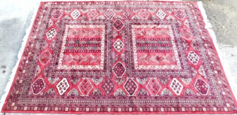 A Kashmir carpet, with a design of medallions on a red ground, with multiple borders, 340cm x 235cm.