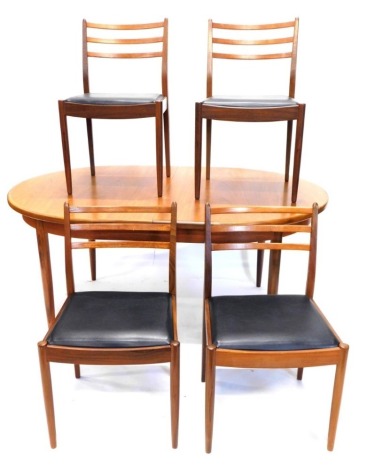 A G-Plan teak extending dining table, with shaped edge on turned legs, 158cm wide, and four matching chairs, each with black leatherette seats. The upholstery in this lot does not comply with the 1988 (Fire & Fire Furnishing) Regulations, unless sold to 