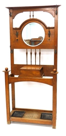 A late 19th/early 20thC oak Arts & Crafts style hall stand, with a central circular bevelled mirror plate, turned supports and cast metal handles, the base with two metal drip trays, 193cm high, 88cm wide.