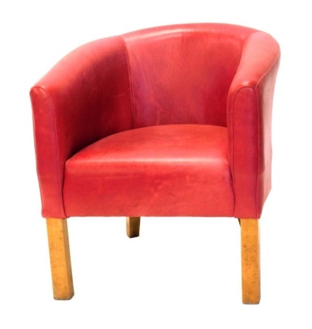 A red leather upholstered tub shaped chair, on square tapering legs. The upholstery in this lot does not comply with the 1988 (Fire & Fire Furnishing) Regulations, unless sold to a known exporter or upholsterer it will be cut from the frame before leavin