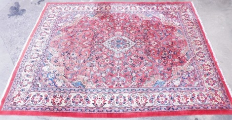 An Indian Mahal carpet, with a design of scrolls, flowers, etc. in red on a cream ground with one wide border and four narrow borders, 435cm x 328cm.