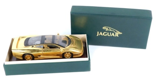 A Jaguar XJ 220 diecast model, in gold on a wooden plinth, in a fitted case.