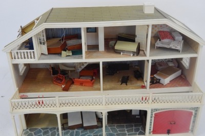 A Lundby doll's house, the house with a tiled roof, and glazed window panels with balcony and lower tier, with an open interior, and various plastic furniture, 64cm high, 92cm wide, 37cm deep. - 2