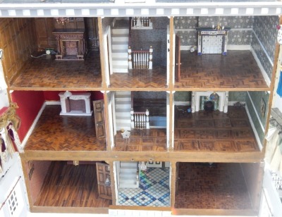 A Tudor style doll's house, with three tiers and pitched roof, with applied bird, with a gate fronted entrance, 102cm high, 95cm wide, 44cm deep. (AF) - 3