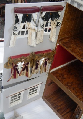 A Tudor style doll's house, with three tiers and pitched roof, with applied bird, with a gate fronted entrance, 102cm high, 95cm wide, 44cm deep. (AF) - 5