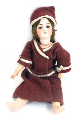 An early 20thC German porcelain bisque headed doll, stamped Germany B4, of a girl in red dress and hat, 59cm high.