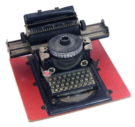 A German 9SN tin plate miniature typewriter, model 3, mounted on board.