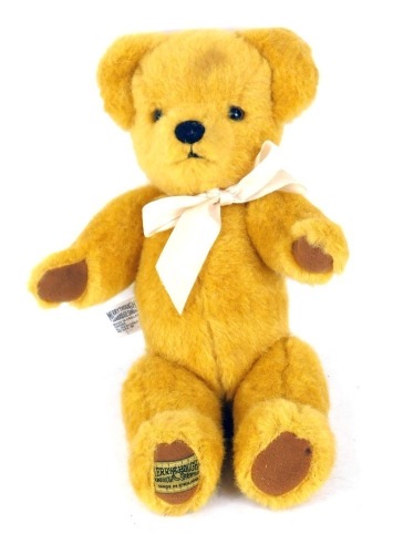 A Merrythought blonde plush jointed Teddy bear, with bow and label to foot, 28cm high.