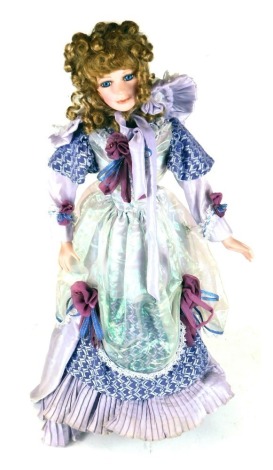 A porcelain collector's doll, in flowing purple dress, on stand, 36cm high.