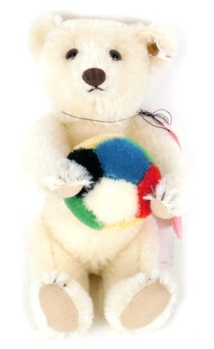 A Steiff exhibition bear, the white bear holding a coloured football, with label to ear, 21cm high, boxed.