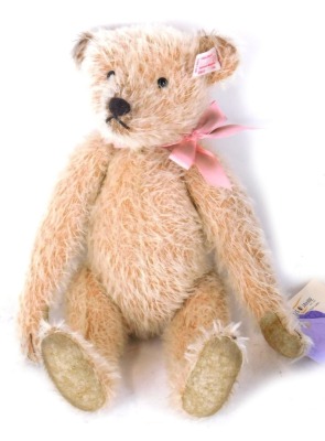 A Steiff Teddy bear 1953, with pink bow, label and button to ear, 25cm high, boxed.