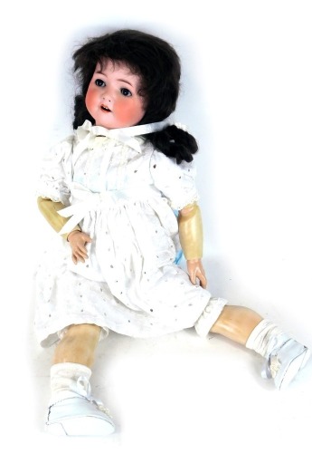 A German Heubach Koppelsdorf bisque headed doll, with closing eyes and articulated limbs, 60cm high.