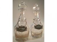 A matched pair of 19thC mallet shaped facet cut decanters with stoppers