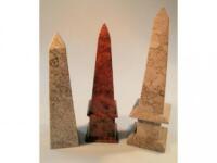 Two modern stone carved obelisks and a yew wood obelisk