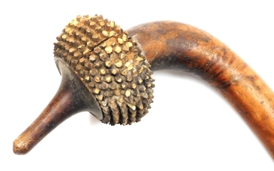 A 19thC Fijian Totokia (Pineapple) war club, of dense hardwood, the curved head carved with ten bands of hobnails, on a straight shaft terminating in a flared grip, 81cm wide.