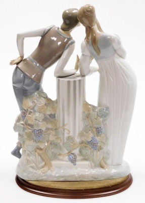 A Lladro porcelain figure group of Romeo and Juliet, modelled leaning against a central fluted column, printed marks, 42cm high, on an associated hardwood base. - 2