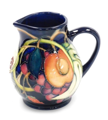 A Moorcroft pottery jug decorated in The Queens Choice pattern, of baluster form, with a sparrow beak spout, 13cm high, boxed with outer slip case.