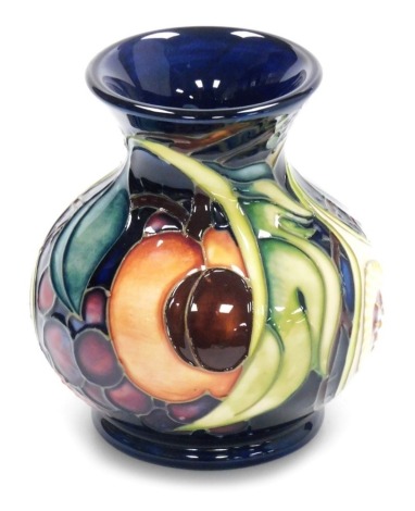 A Moorcroft pottery vase decorated in The Queens Choice pattern, of baluster form with a flared neck, impressed and painted marks, 11.5cm high, boxed.