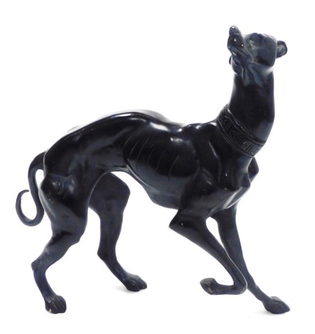 A 20thC bronze sculpture of a Whippet, modelled standing with one front leg raised, 40cm high.