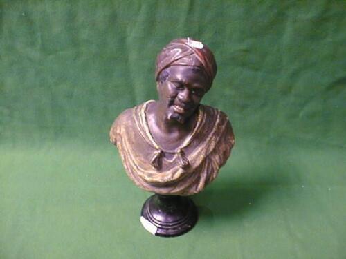 A terracotta Bust of an Blackamoor wearing a red turban and gold tasselled cloak