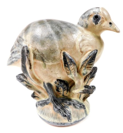 A Danish Ingdam pottery figure of a bird, modelled nestled among plants, on an oval foot, impressed marks, 18cm high.